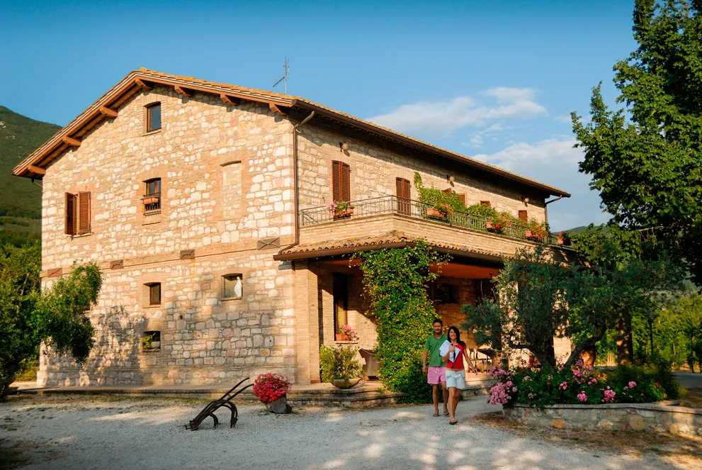 La facciata in pietra della casa con il giardino